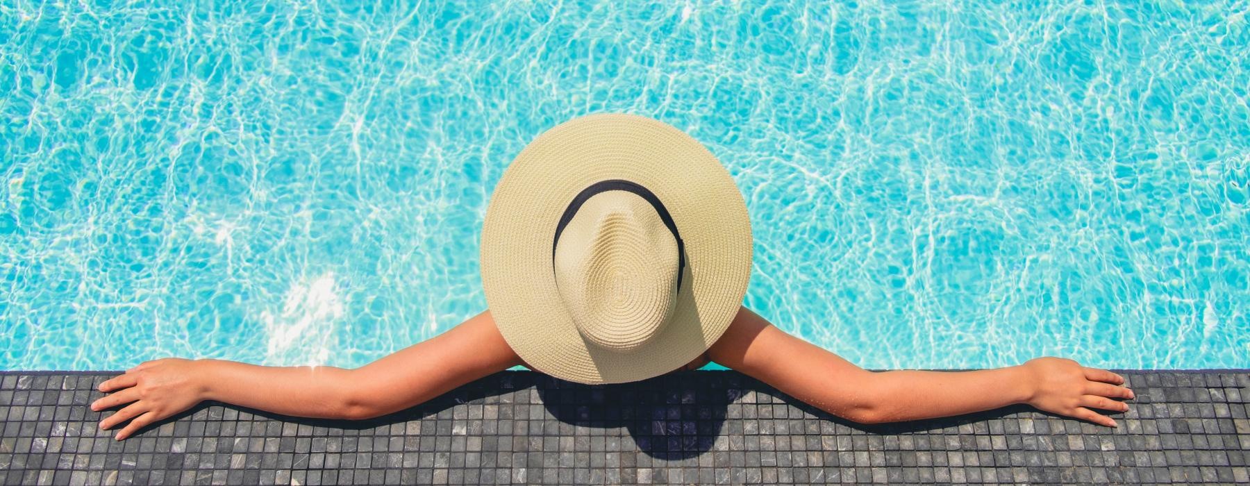 a person lying in a pool with a hat on