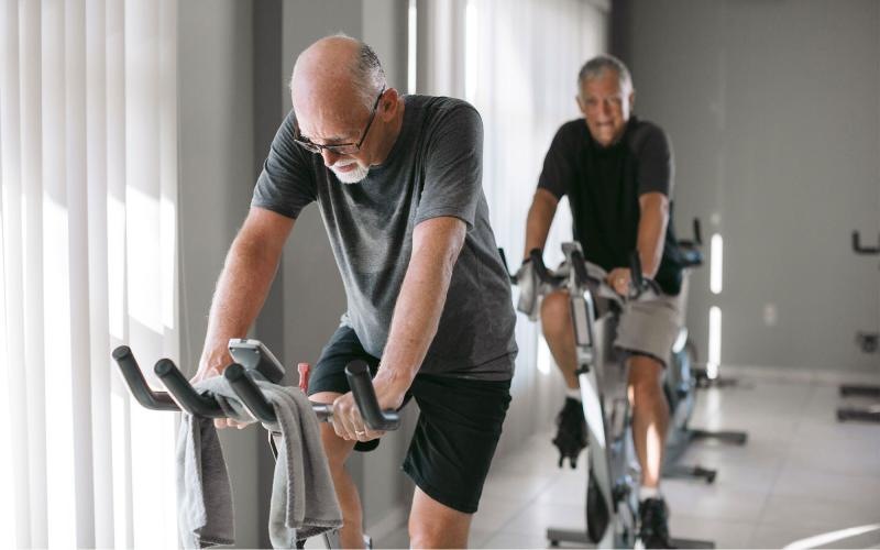 two men working out on a bicycle