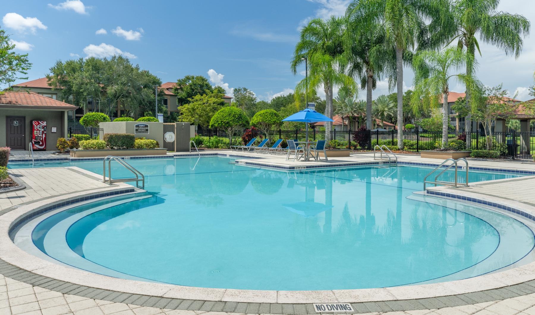 a pool with trees and buildings around it